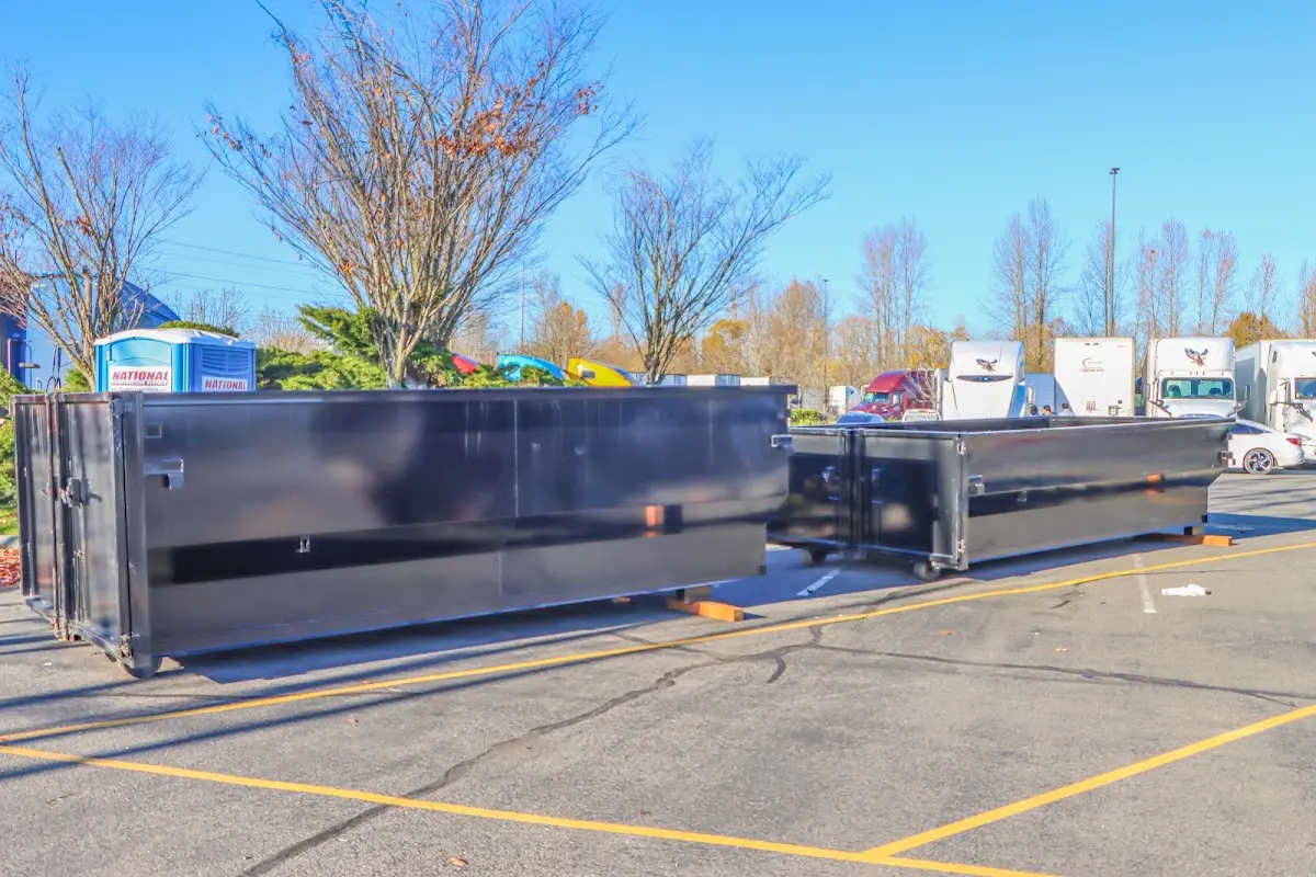 Professional dumpster rental service with roll-off container on residential driveway in Middle